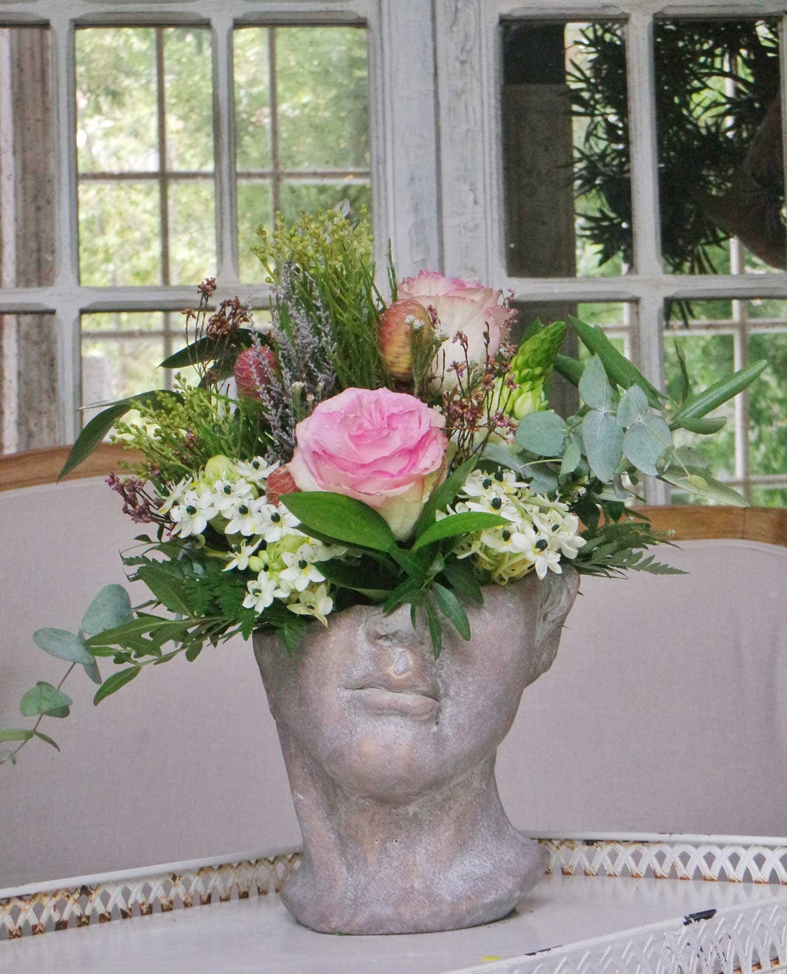 Arreglo de flor en maceta de busto griego