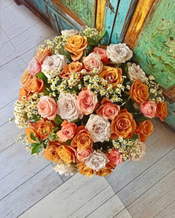 Jarrón con rosas de jardín variadas y verdes